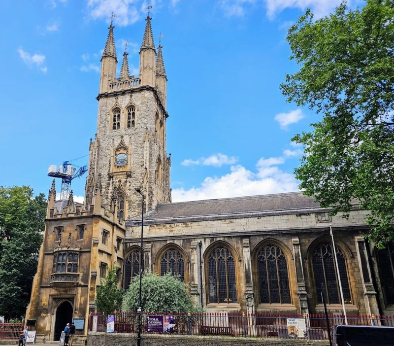 Photo of the Holy Sepulchre Church in London against a bright blue sky